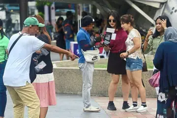DESAK PELANCONG: Jurugambar dekati pelancong di kawasan KLCC untuk ambil gambar mereka.