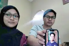 Encik Muhammad Amir Hakimi dan kakaknya, Cik Suraiya Izzaty, menunjukkan gambar bapa mereka, Encik Sabari Baharom, 62 tahun, yang hilang sejak 3 September lalu. 