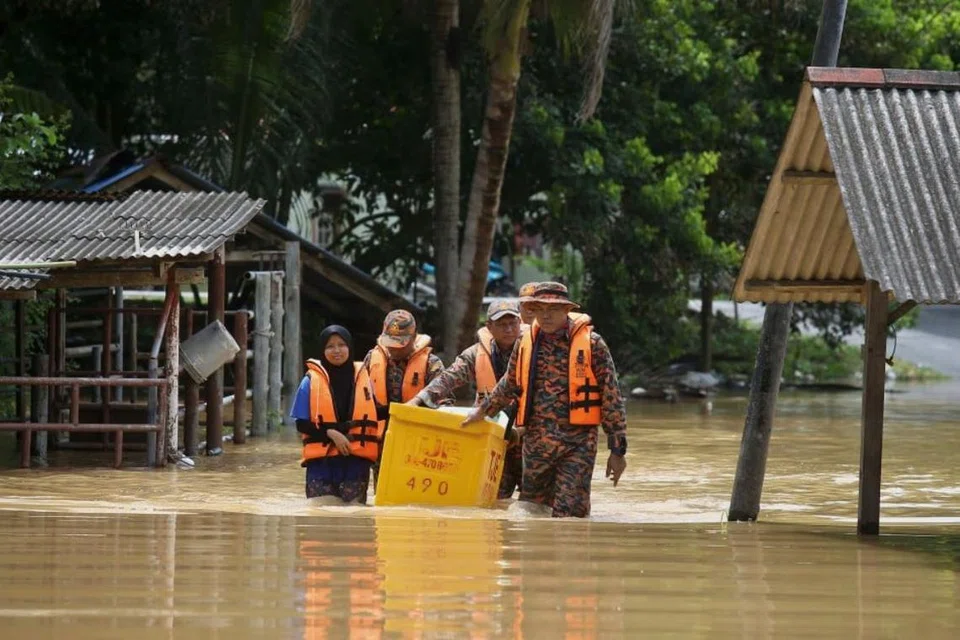 Anggota Jabatan Bomba dan Penyelamat Jitra, Kedah, menyelamatkan seorang mangsa banjir di Kampung Padang Luar, Jitra.