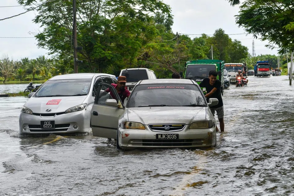AIR MELIMPAH: Pemandu kenderaan mengharungi air yang melimpah ke jalan raya dekat Kampung Sri Sentosa di Bachok, Kelantan, berikutan banjir kilat susulan hujan lebat.