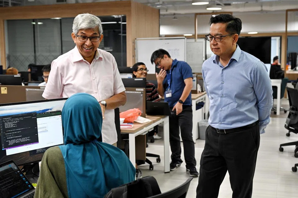 Penasihat AI Singapura, Profesor Yaacob Ibrahim (kiri), bersama Pengarah Inovasi AI Singapura, Encik Laurence Liew (kanan), berinteraksi bersama peserta Program Perantisan AI.