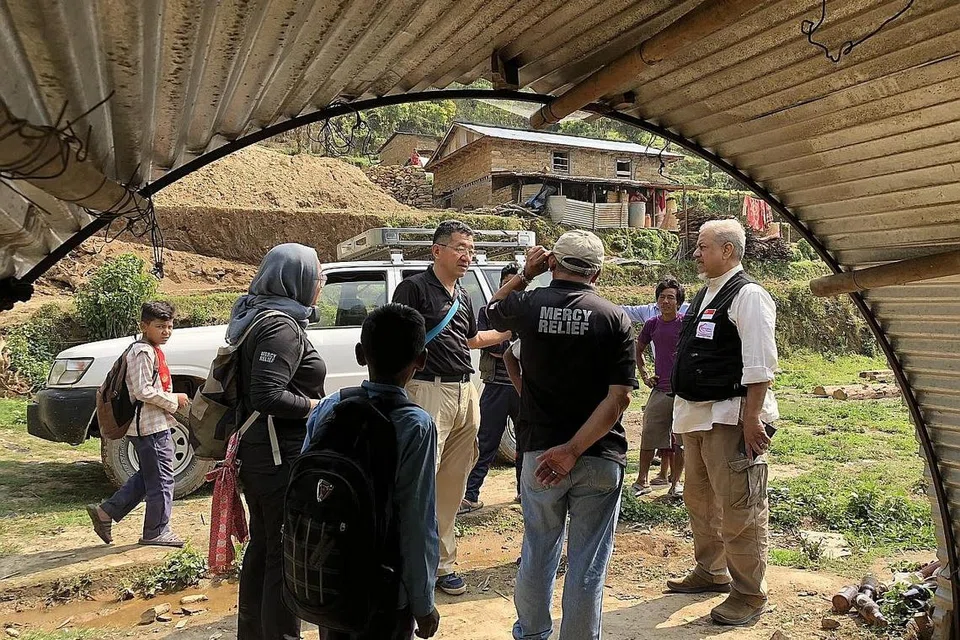 LAWAT KAWASAN TERJEJAS: Encik Masahiro (empat dari kiri) dan Encik Zainul Abidin (paling kanan) merupakan antara delegasi Mercy Relief dan RLAF yang telah ke Nepal hujung bulan lalu sempena ulang tahun keempat gempa bumi yang melanda negara tersebut. - Foto BH oleh NUR FATHIN AWALLUDIN