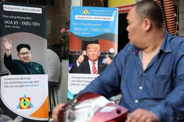 INGIN GAYA RAMBUT SEPERTI TRUMP ATAU JONG UN? Seorang penungang motosikal ini melalui kedai memotong rambut yang menawarkan potongan percuma bagi gaya rambut Presiden Donald Trump dan pemimpin Korea Utara Kim Jong-un di Hanoi, Vietnam, kelmarin. Kededua pemimpin itu akan mengadakan pertemuan di ibu kota Vietnam itu pada 27-28 Februari. - Foto EPA-EFE