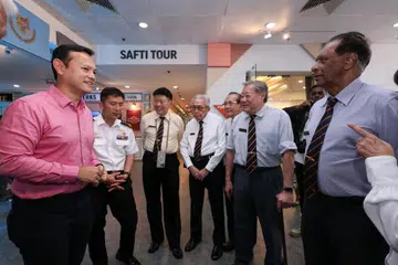 Menteri Negara Kanan (Pertahanan merangkap Tenaga Manusia), Encik Zaqy Mohamad (kiri), beramah mesra dengan Pegawai Waran Pertama (1WO) yang telah bersara, Encik Mohamed Haniffa Jainul Abitheen (kanan), dan veteran Angkatan Bersenjata Singapura (SAF) lain semasa pelancaran Pameran Peringatan ke-60 SAF (SAF60) yang dilancarkan di Wisma Teroka Singapura (SDC) pada 2 April. Bersama Encik Zaqy ialah Panglima Pasukan Pertahanan, Laksamana Madya (VADM) Aaron Beng (dua dari kiri).
