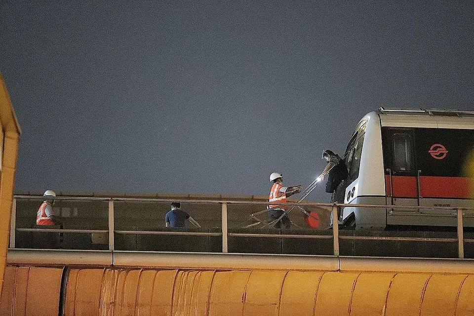 KEJADIAN: Penumpang yang terjejas turun dari kereta api dengan bantuan kakitangan SMRT dan berjalan di sepanjang landasan jalan untuk kembali ke stesen. Kerosakan selama tiga jam di laluan MRT Utara-Selatan, Timur-Barat dan Circle pada 14 Oktober lalu disebabkan kabel elektrik yang rosak mengakibatkan bekalan terputus di beberapa stesen, mengganggu perjalanan waktu sibuk sebelah petang untuk banyak penumpang.