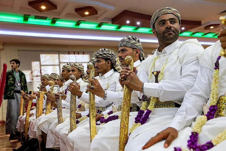 RAJA-RAJA SEHARI: Barisan pengantin lelaki segak berpakaian tradisional Yemeni menghadiri majlis perkahwinan beramai-ramai pada 17 Februari lalu untuk 70 pejuang yang sebelum ini merupakan tawanan perang, di ibu kota Sana'a yang ditawan pemberontak Houti. - Foto AFP