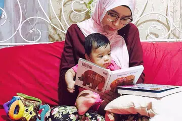 PUPUK DARI AWAL: Sejak Cik Munirah masih kecil lagi, ibu serta bapanya kerap membawanya ke Perpustakaan Negara untuk memupuk minat membaca. Kini, setelah melahirkan anaknya, beliau meneruskan tradisi tersebut dengan membawa anaknya pula ke sana. - Foto ihsan MUNIRAH JAAFAR