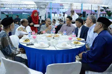 BUKA BERSAMA: Encik Masagos (tengah) menyertai satu majlis berbuka puasa anjuran Darul Arqam kelmarin, di mana badan itu telah menyampaikan cek $20,000 kepada Mercy Relief dan melancarkan buku panduan baru bagi muallaf. Bersamanya ialah antara lain Presiden Darul Arqam, Encik Imran Kuna (dua dari kiri) dan CEO Muis, Encik Esa Masood (empat dari kanan). - Foto DARUL ARQAM