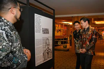 PAMERAN RELAWAN: Timbalan Perdana Menteri, Encik Lawrence Wong (kanan), melihat pameran yang mengetengahkan beberapa relawan 4PM sambil ditemani Presiden 4PM, Encik Nassar Mohamad Zain (di sebelah Encik Wong) pada majlis makan malam sempena ulang tahun ke-75 4PM di The Ritz-Carlton Millenia. 