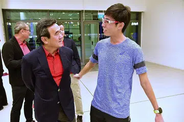 TIDAK SEHALA: Presiden Atletik Singapura Tang Weng Fei (kiri) berinteraksi bersama atlet maraton nasional Soh Rui Yong pada 2018. - Foto fail BH