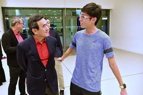 TIDAK SEHALA: Presiden Atletik Singapura Tang Weng Fei (kiri) berinteraksi bersama atlet maraton nasional Soh Rui Yong pada 2018. - Foto fail BH