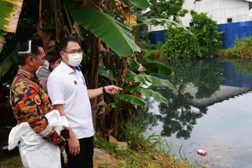 Pengerusi Jawatankuasa Kesihatan dan Alam Sekitar Johor, Encik Ling Tian Soon (dua dari kiri) bersama anggota bomba melihat air Sungai Pandan yang berwarna hitam dan berbau busuk, disyaki menjadi punca pencemaran bau bahan kimia di Kampung Melayu Pandan; Taman Daya; Taman Mount Austin dan Taman Istimewa, di Johor Bahru, pada 3 September.