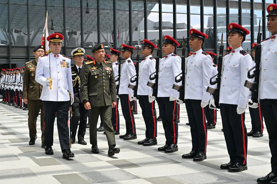 Jeneral Malek (Berjalan, kanan) semasa memeriksa Kawalan Kehormatan di Mindef pada 9 April.