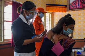BHUTAN: Lebih 93 peratus warga dewasa telah divaksinasi seperti wanita dalam gambar ini (kanan) yang menerima dos antivirus. Sejauh ini Bhutan catat ebih 1,100 kes Covid-19, 1,000 telah sembuh dan hanya satu kematian dicatatkan. - Foto AFP