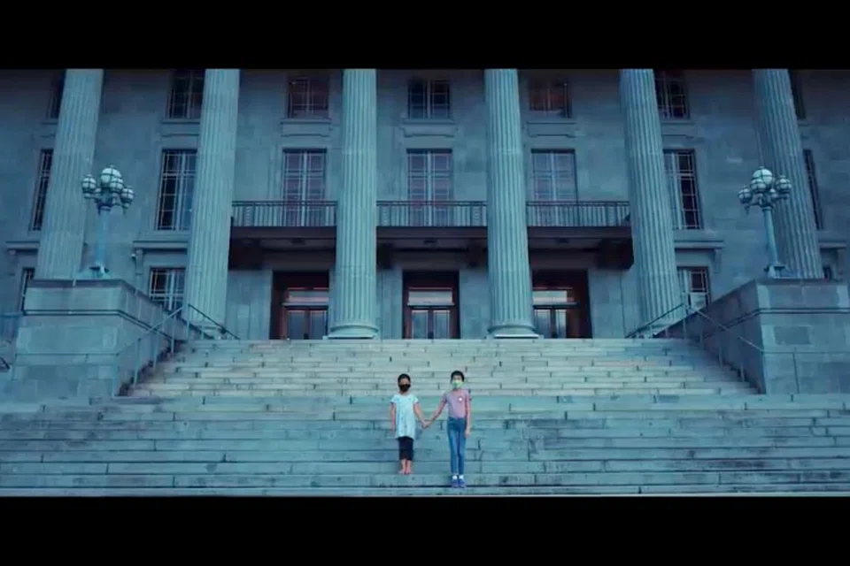PENUH MAKNA: Di adegan akhir video 'Majulah Singapura', diperlihatkan gambaran dua orang kanak-kanak berpimpin tangan, berlari naik ke anak-anak tanggga bangunan ikonik Singapura - satu gambaran pengharapan besar depan yang cukup simbolik. - Foto YOUTUBE GOV.SG