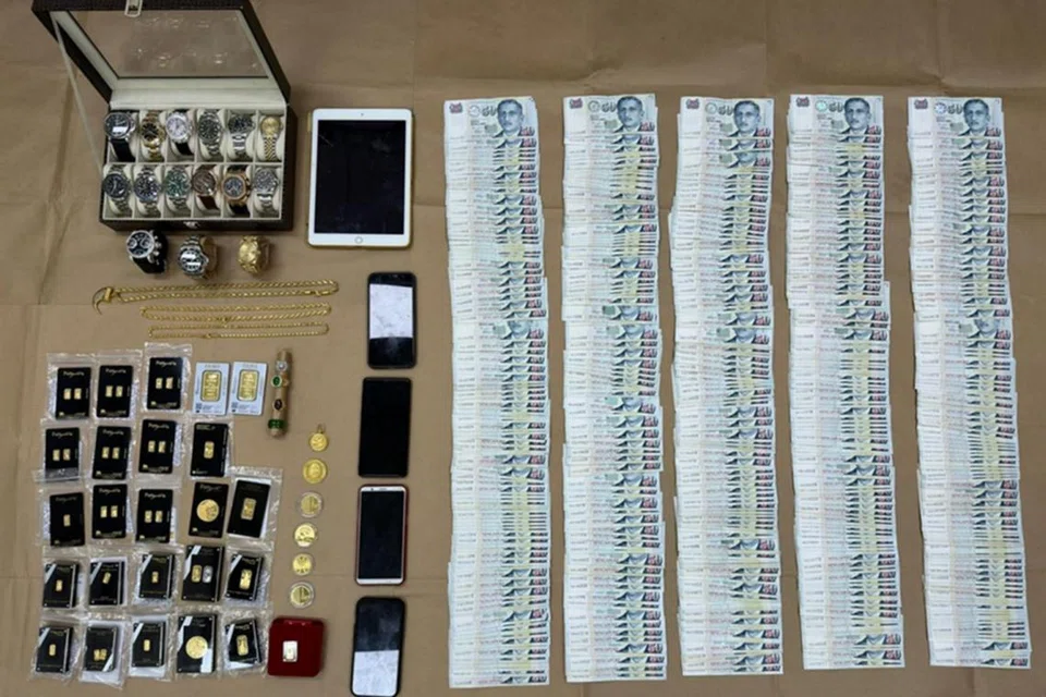 RAMPASAN SERBUAN: Barang dirampas dari rumah dua tertuduh  termasuk wang tunai berjumlah lebih $25,000, 15 jam tangan mewah, serta emas yang terdiri daripada 34 keping, tujuh syiling, tiga cincin dan satu loket.