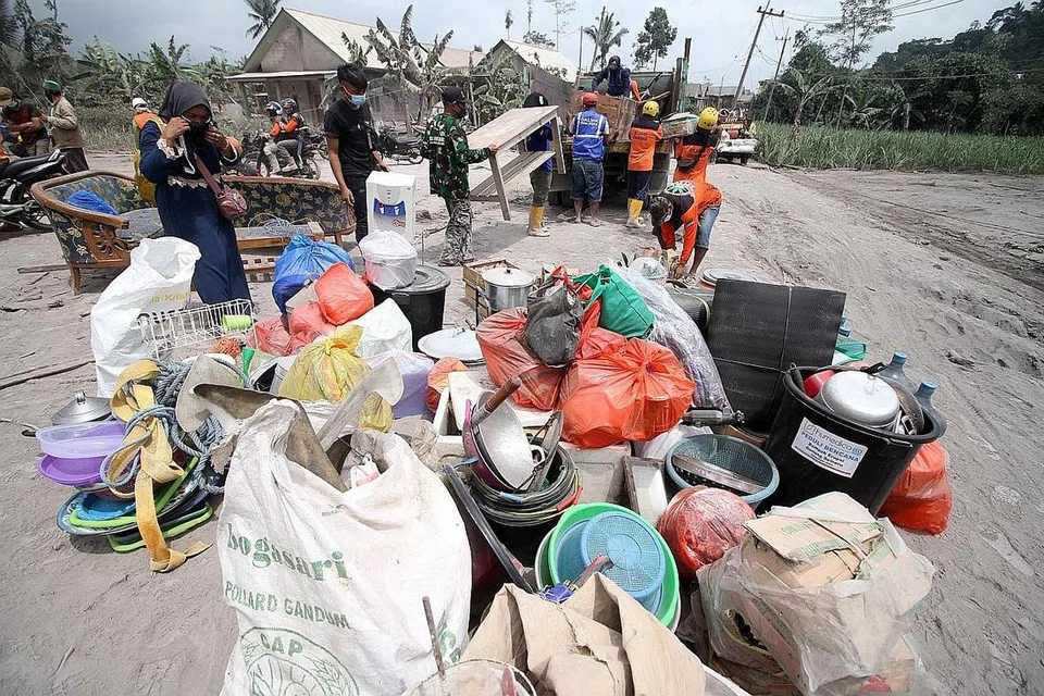 PERLU BERPINDAH: Para penduduk kampung Kajar Kuning, di Lumajang, Jawa Timur, semalam memunggah barang keperluan ke atas lori selepas mereka diarah berpindah susulan letusan gunung berapi Semeru. - Foto EPA-EFE