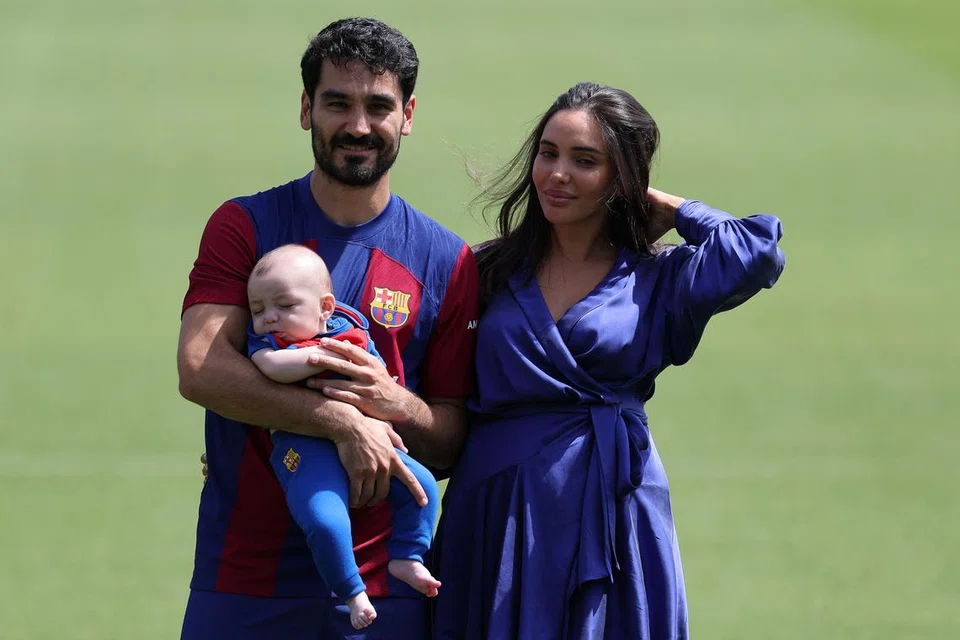 SELESA DI KELAB BARU: (Dari kiri) Pemain midfield asal Jerman, Ilkay Gundogan, bersama anak dan isterinya, Sara Arfaoui, bergambar semasa sesi perkenalan di pusat latihan Barcelona di Sant Joan Despi. 
