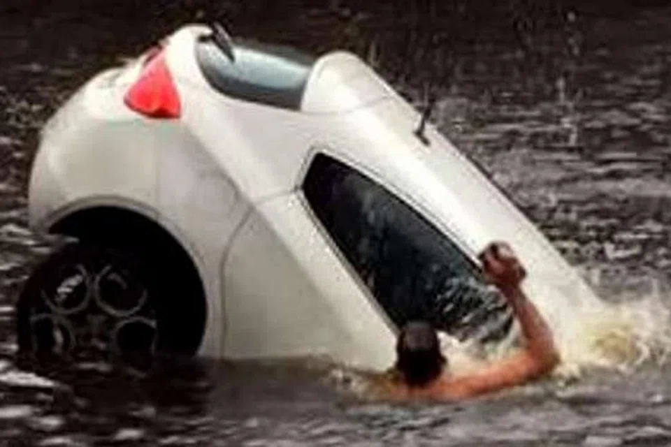DISANJUNG: Gambar ini, yang diambil daripada rakaman video, menunjukkan seorang lelaki cuba memecahkan tingkap kereta untuk menyelamatkan anak kecil yang terperangkap di dalamnya. - Foto YOUTUBE