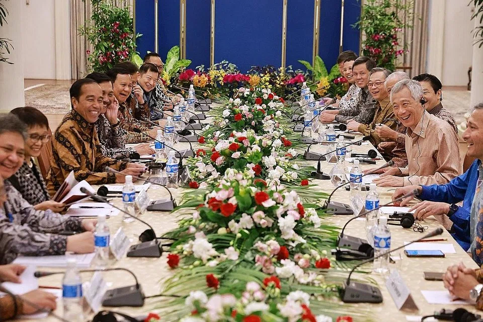 BINCANG TENTANG KERJASAMA: Encik Lee Hsien Loong (tengah, kanan) dan Encik Joko Widodo (tengah, kiri) bersama delegasi masing-masing berbincang mengenai pelbagai bidang kerjasama semasa Rahat Pemimpin Singapura-Indonesia 2023 di Istana. - Foto ST