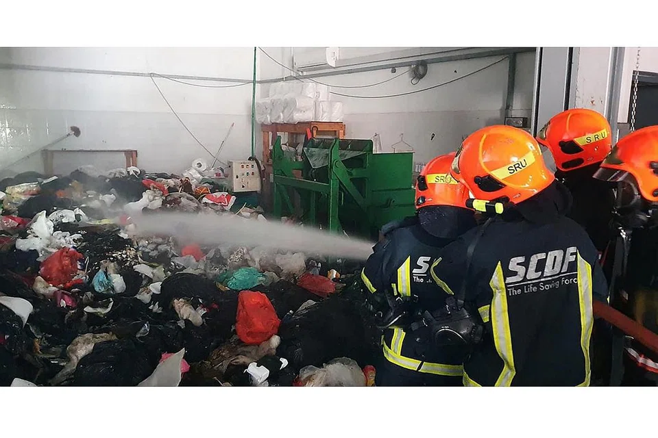 HAPUSKAN KLORIN: Pancuran air digunakan bagi mencairkan wap gas klorin di dalam bilik pemadat sampah di tingkat bawah bangunan perusahaan Nordcom II di Gambas Crescent semalam. - Foto SHIN MIN