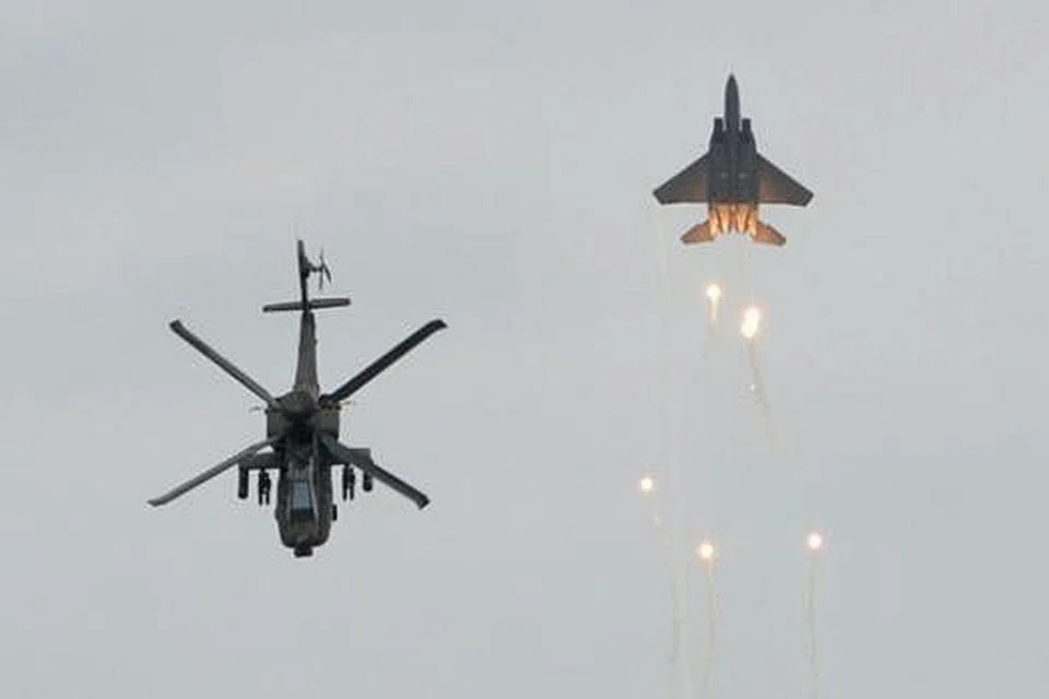 PERTUNJUKAN MEMUKAU: Helikopter AH-64D membuat gerakan seolah-olah memberi tabik bersama jet pejuang F-15SG.