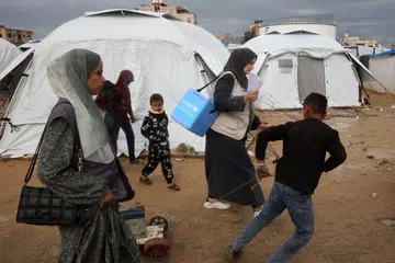 Petugas perubatan daripada Unicef membawa kotak penyejuk berisi vaksin polio di sebuah kem pelarian di Nuseirat, di bawah kempen vaksinasi polio besar-besaran kali ketiga di Gaza. Ia bertujuan memberi dos pertama kepada hampir 600,000 kanak-kanak di seluruh wilayah Palestin.