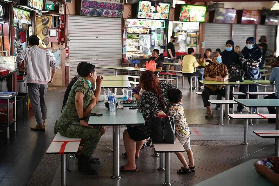 DUDUK BERSAMA:Gambar yang dirakam di Pusat Makanan Bedok semalam ini menunjukkan pelanggan sudah mula mengisi ruang dengan duduk lima semeja namun gerai di belakang masih ada yang belum dibuka. - Foto BH oleh ARIFFIN JAMAR