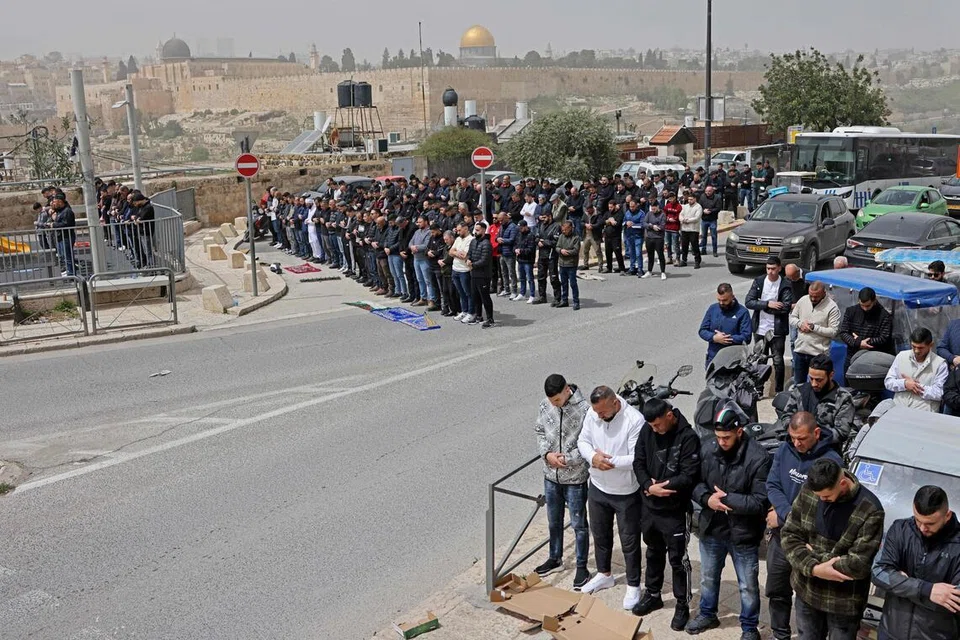 Umat ​​Islam Palestin menunaikan solat Jumaat di kejiranan Ras al-Amuddi di Baitulmakdis, pada 3 April 2026, berlatarbelakangkan Kubah As-Sakhrah. Pekarangan Masjid Al-Aqsa masih ditutup sejak perang Amerika Syarikat-Israel dengan Iran bermula pada 28 Februari.