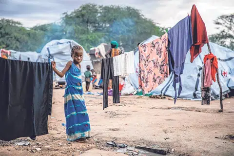 PELARIAN IKLIM: Seorang kanak-kanak berdiri di sidaian pakain di kem pelarian untuk keluarga yang dipindahkan akibat banjir di Garissa, Kenya, Afrika, pada November 2023. Negara Afrika mengalami hujan lebat dan banjir yang dikaitkan gejala El Nino. Beberapa komuniti dipindahkan akibat ribuan rumah musnah atau rosak akibat banjiir yang melanda sekurang-kurangnya 33 daripada 47 daerah Kenya mengorbankan lebih 70 orang dan menyebabkan ramai kehilangan tempat. tinggal di selruh negara Afrika Timur.