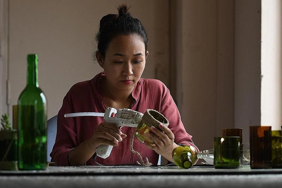 KITAR SEMULA: Seorang pekerja menggunakan gam untuk mengitar semula sebiji botol yang dikumpul dari Gunung Everest. - Foto Fail AFP