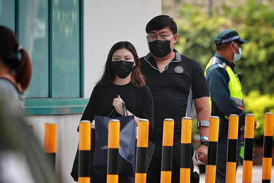KELUARGA TERKEJUT: Teman keluarga dan pengarah pengebumian, Encik Fong Chun Cheong (belakang), berjalan bersama kakak kededua mangsa di rumah mayat Hospital Besar Singapura.