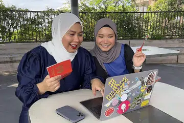 MELAKUKAN PERANCANGAN: Cik Siti Aisyah (kanan) dan Cik Nur Aisyah telah melakukan perancangan untuk perjalanan mereka ke Australia sebaik sahaja pengumuman kelonggaran udang-undang diumumkan.