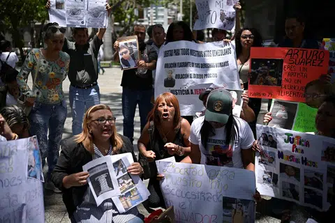 Ahli keluarga warga Venezuela yang kini ditahan di sebuah penjara dengan kawalan keselamatan tinggi di El Salvador selepas dihantar pulang dari Amerika Syarikat, memegang plakad dan gambar insan tersayang semasa tunjuk perasaan bagi menuntut pembebasan mereka, di Caracas, Venezuela, 24 Mac 2025.