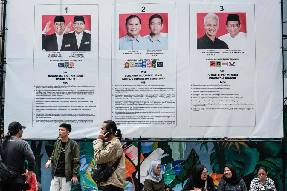 BAKAL MEMILIH: Orang ramai duduk di bawah poster tiga pasangan calon presiden dan naib presiden menjelang Pilihan Raya Umum Indonesia yang dijadualkan pada 14 Februari 2024 dekat pejabat Suruhanjaya Pilihan Raya Umum Indonesia (KPU) di Jakarta pada 2 Januari. 