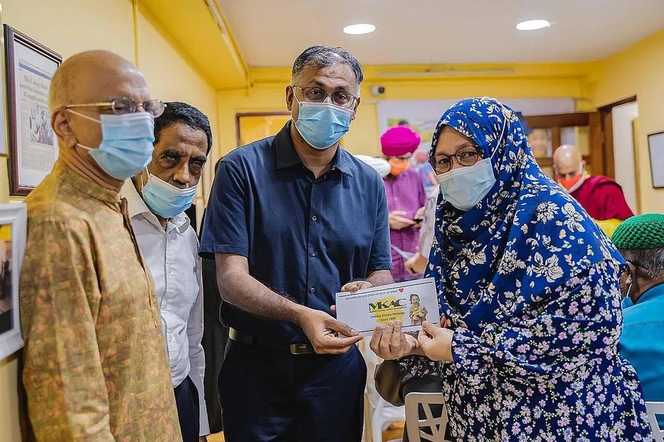 IFTAR PERERAT JALINAN: Encik Murali Pillai dan Encik Ameerali Abdeali serta wakil agama lain dan IRO di majlis iftar MKAC. Encik Murali turut menyampai habuan kepada penerima MKAC, termasuk Cik Siti Aminah Safari, yang mewakili suaminya. - Foto-foto BH oleh NUR DIYANA TAHA