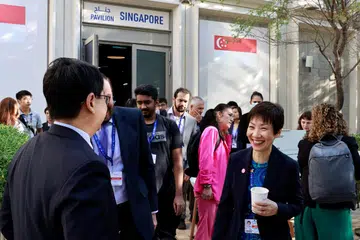 SALING MEMBANTU: Menteri Kemampanan dan Sekitaran, Cik Grace Fu (kanan), di luar pavilion Singapura bagi perbincangan iklim COP28 Pertubuhan Bangsa-Bangsa Bersatu di Dubai, Amiriah Arab Bersatu (UAE), pada 11 Disember.