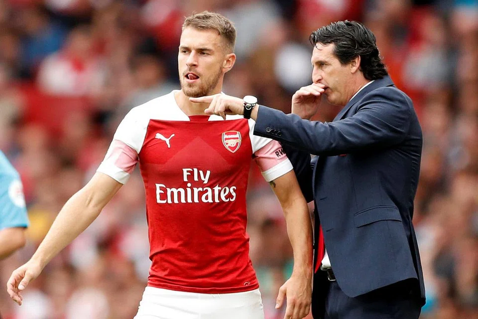 TUNJUKKAN STRATEGI: Emery (kanan) membisikkan cara permainan yang dikehendakinya kepada Aaron Ramsey dalam perlawanan menentang Manchester City Ogos lalu. - Foto REUTERS