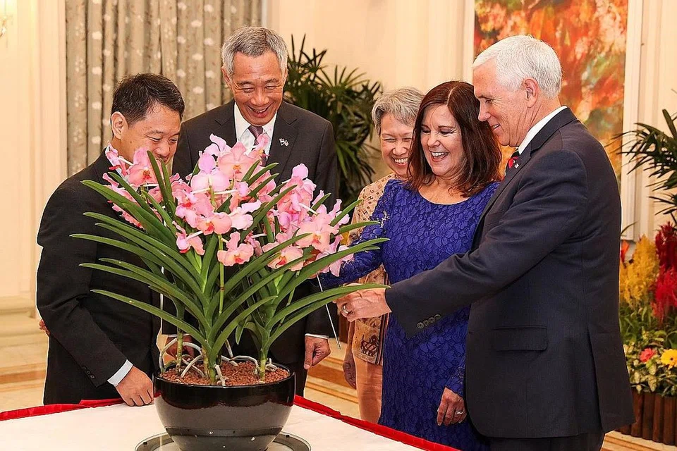HADIAH ISTIMEWA: Encik Lee dan isterinya, Cik Lee (dua dan tiga dari kiri) menghadiahkan anggerik kacukan khas yang diberi nama Papilionanda Mike and Karen Pence, kepada Encik Pence (kanan) dan Cik Pence (dua dari kanan). - Foto REUTERS