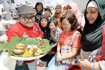 MENYELERAKAN: Cef Mel (kiri) menunjukkan Nasi Liwet Solo, Ayam Panggang Temasek dan Salsa Nanas Thailand kepada peserta yang hadir di demonstrasi makanan anjuran Harvey Norman dan BH/BM yang diadakan di gudang Harvey Norman Millenia Walk semalam. - Foto ZAINAL YAHYA