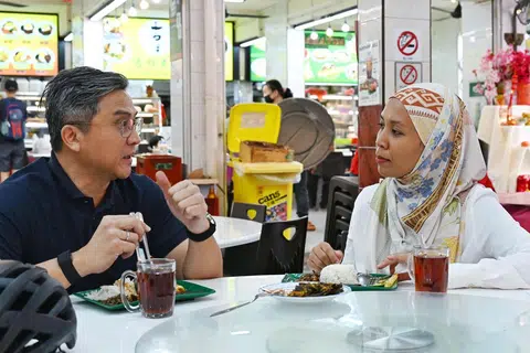 Anggota Parlimen (AP) GRC Bishan-Toa Payoh, Encik Saktiandi Supaat, bersembang dengan wartawan Berita Harian, Cik Nur Dhuha Esoof, sambil menikmati nasi lemak $1 dari Kedai Makan Muhajirin di Blok 20 Toa Payoh Lorong 7.