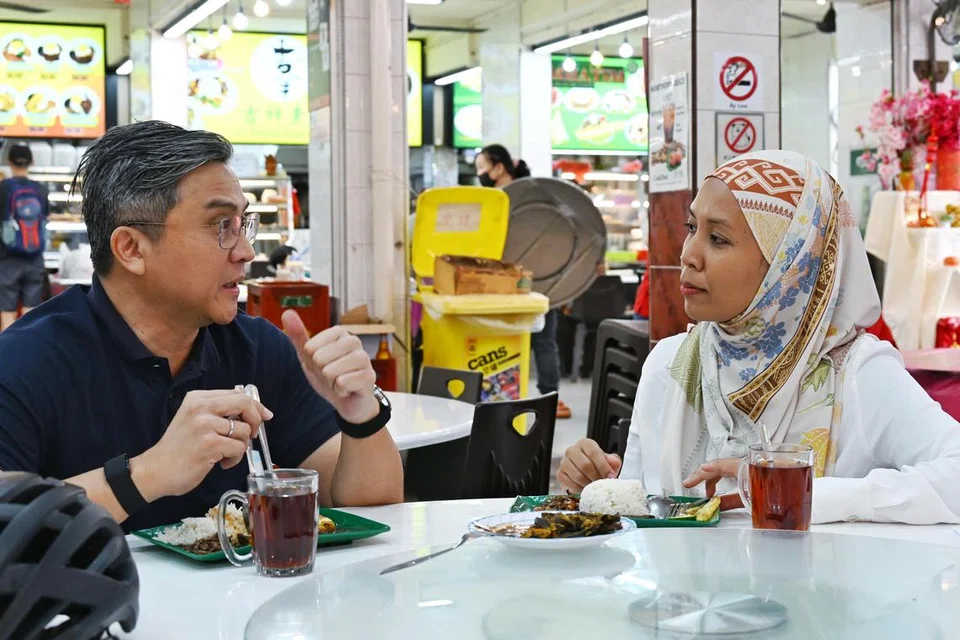Anggota Parlimen (AP) GRC Bishan-Toa Payoh, Encik Saktiandi Supaat, bersembang dengan wartawan Berita Harian, Cik Nur Dhuha Esoof, sambil menikmati nasi lemak $1 dari Kedai Makan Muhajirin di Blok 20 Toa Payoh Lorong 7.