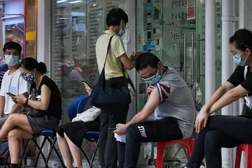 DAPATKAN VAKSIN SINOVAC: Orang ramai menunggu di luar sebuah klinik di Toa Payoh semalam untuk kesihatan mereka dipantau setelah mengambil vaksin Sinovac. - Foto BH oleh KUA CHEE SIONG