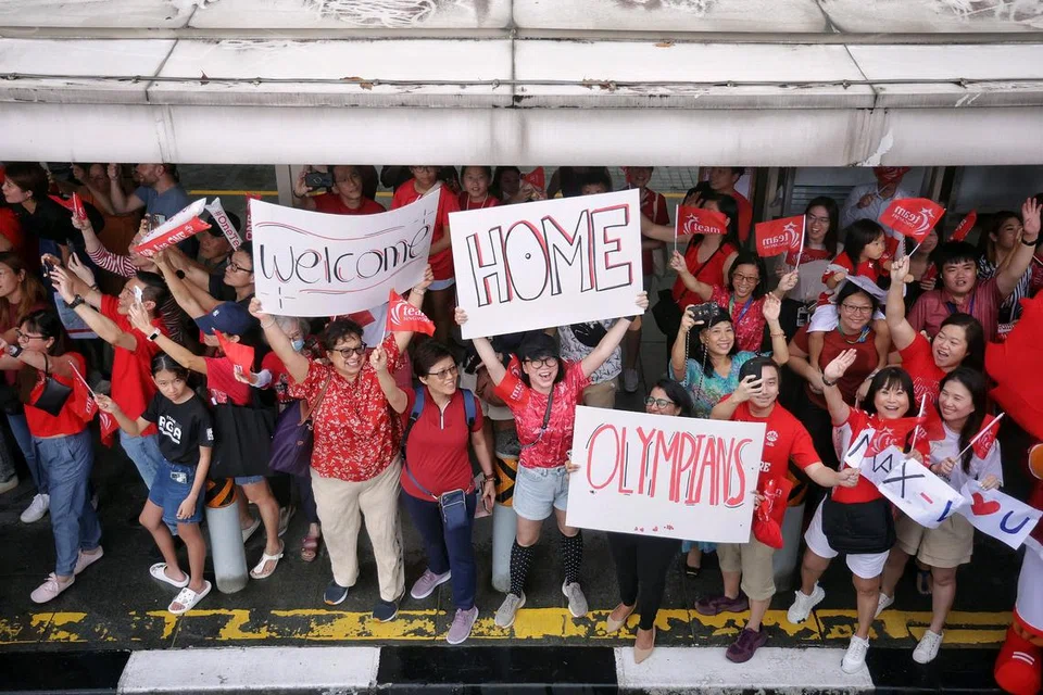 Selain memakaikan pakaian merah, para penyokong menyambut ketibaan atlet negara di atas bas yang tidak berbumbung itu dengan sepanduk.