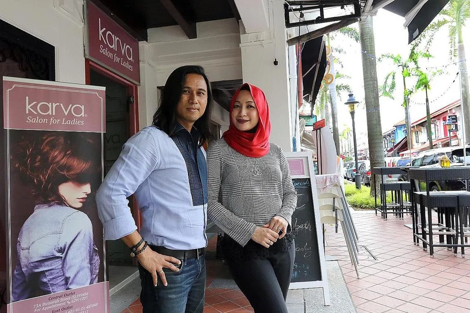 TERUS BERKEMBANG: Jai Wahab dan Rozza Ramli di luar salun cawangan Bussorah Street mereka. Pasangan selebriti ini mahu mengembangkan salun mereka ke utara Singapura dan luar negara. - Foto SHAHRIYA YAHAYA