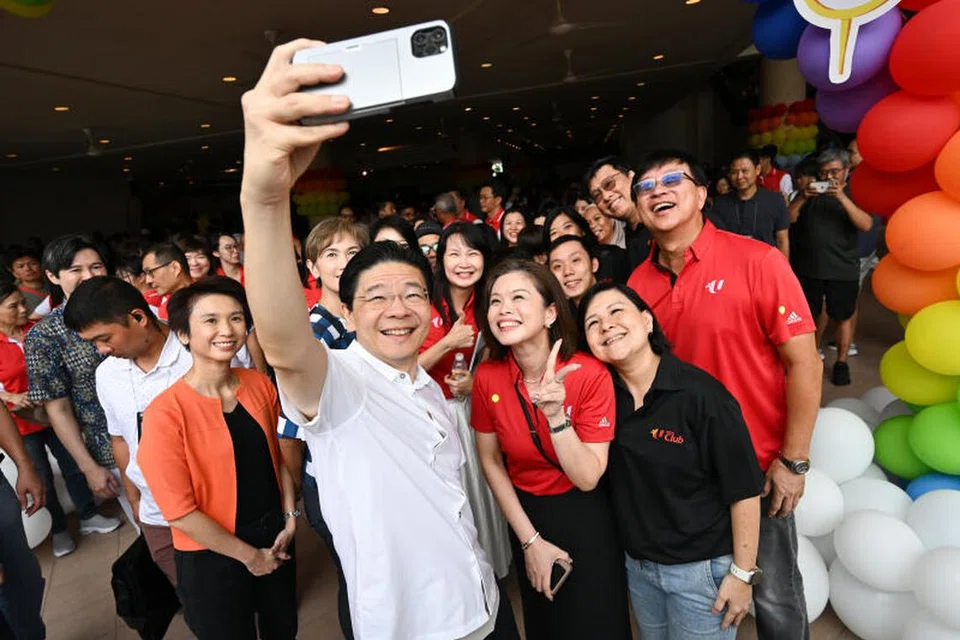 Perdana Menteri, Encik Lawrence Wong (berbaju putih), bergambar bersama Menteri Negara Kanan (Kebudayaan, Masyarakat dan Belia merangkap Perdagangan dan Perusahaan), Cik Low Yen Ling (kiri, berbaju oren); Menteri Penerangan dan Pembangunan Digital, Cik Josephine Teo (belakang, berbaju kotak-kotak) dan anggota Kelab NTUC.