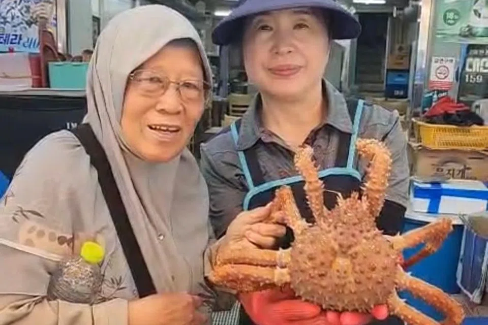 Cik Napsiah puas dengan pilihannya di pasar makanan laut di Busan dan bergambar bersama pegerai.