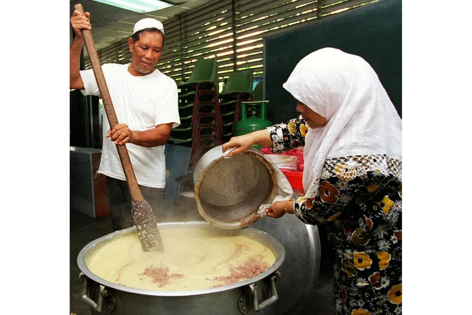 MASJID RADIN MAS: Dua relawan di Masjid Radin Mas menyumbang masa dan tenaga dalam menyiapkan bubur dalam gambar yang dirakam pada 1997. - Foto-foto fail 