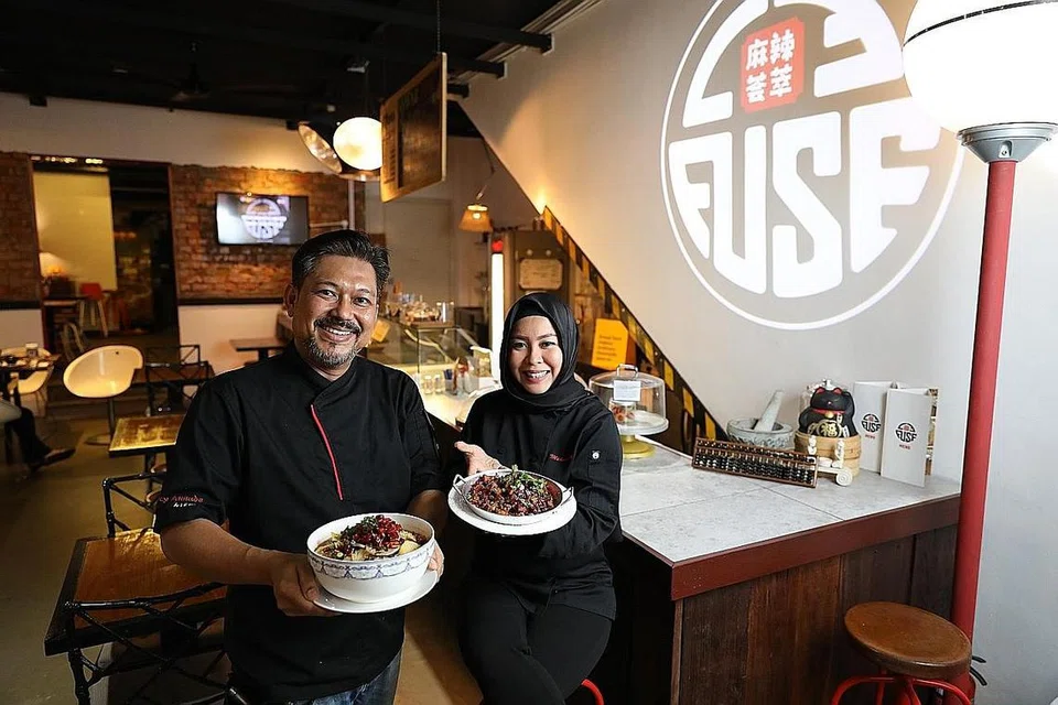 JATUH CINTA DENGAN MASAKAN SICHUAN: Encik Leonadi Ramli, yang membuka restoran Le Fuse bersama rakan kongsinya, Cik Hanney Esa, menunjukkan dua jenis masakan Sichuan yang dihidangkan di restorannya. Beliau membuka restoran itu setelah bertahun-tahun meniaga nasi padang. - Foto BM oleh ONG WEE JIN