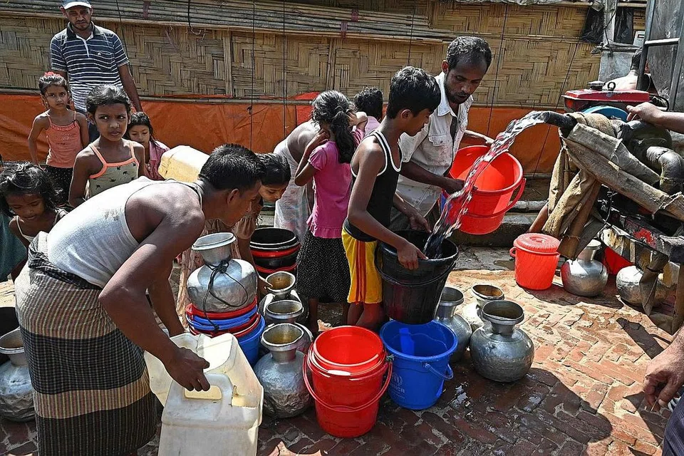 CARI TEMPAT BERLINDUNG: Pelarian Rohingya mengambil air dari kem pelarian di Kutupalong di Ukhia, Bangladesh - negara yang juga bergelut untuk menyokong jumlah pelarian yang ramai. - Foto AFP